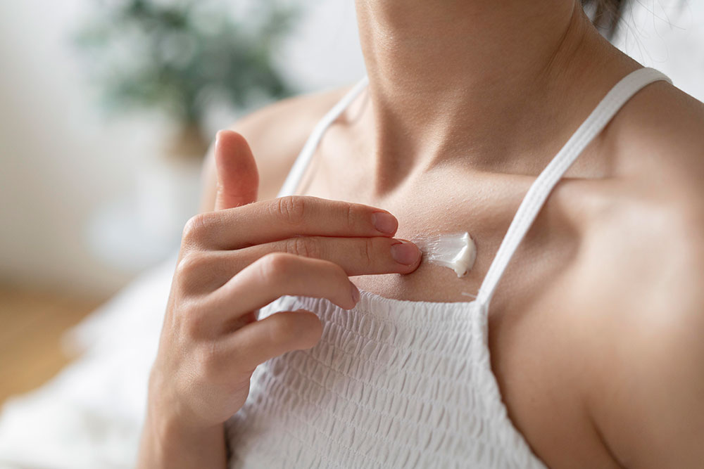woman applying topical vitamins to skin